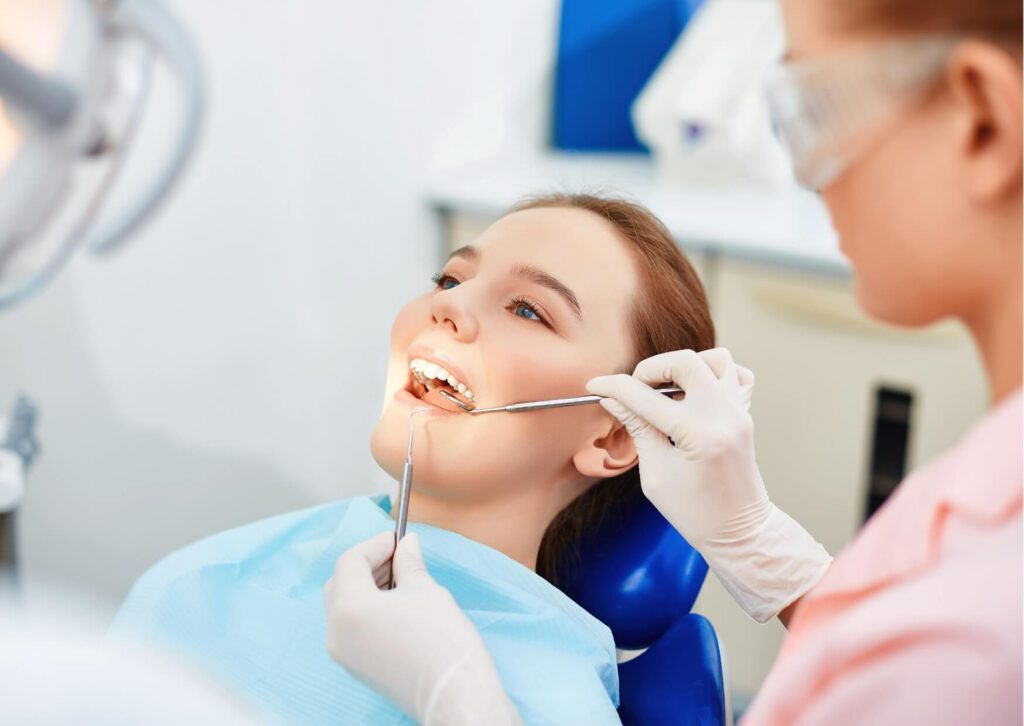 Dentist examining a patient's teeth during a dental visit, discussing what happens after tooth loss and whether a tooth can grow back naturally.
