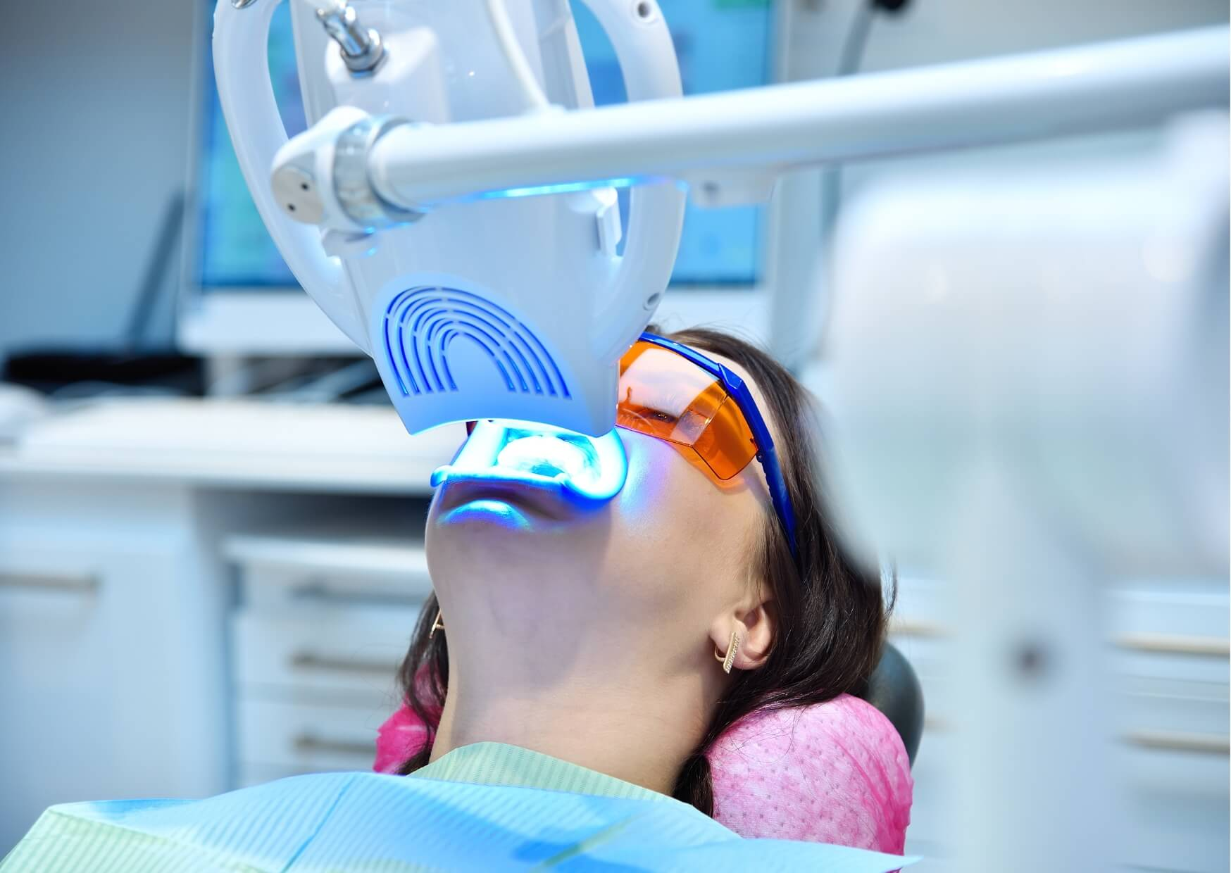 Patient undergoing in-office teeth whitening treatment with a whitening light, one of the most effective professional teeth whitening options.