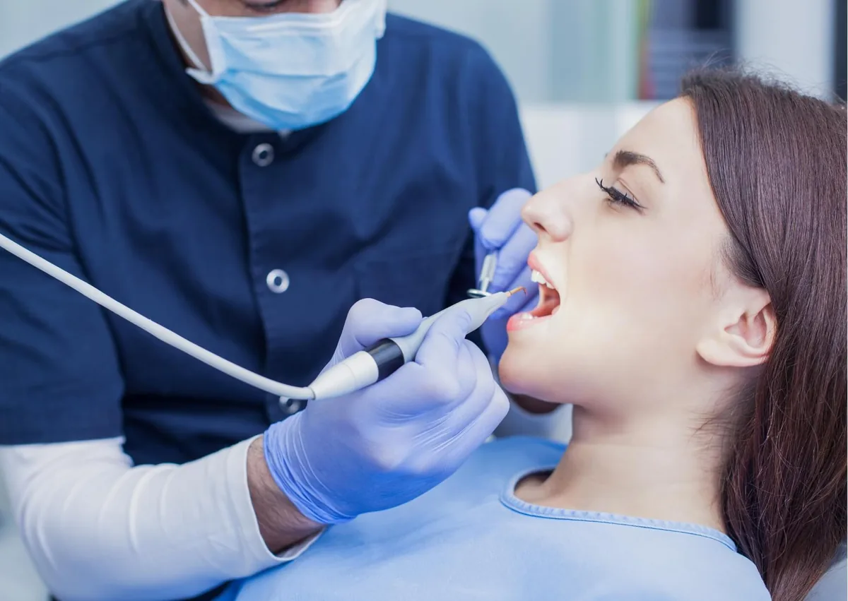 Dentist examining a patient’s gums for signs of gingivitis vs. periodontitis during a dental visit.