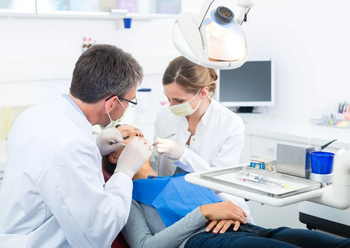 Dental team performing a procedure on a patient that may involve dental implant removal.