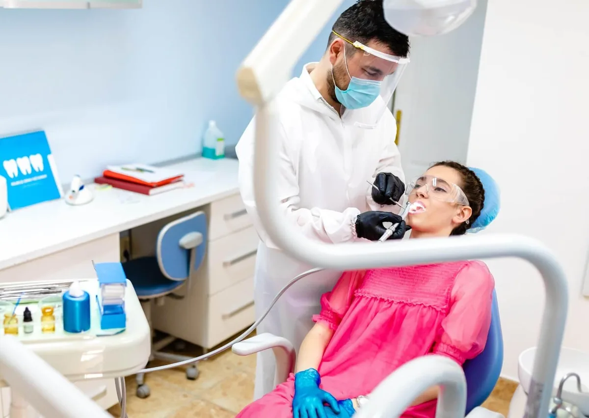 Dentist preparing a patient’s teeth for dental bonding treatment.