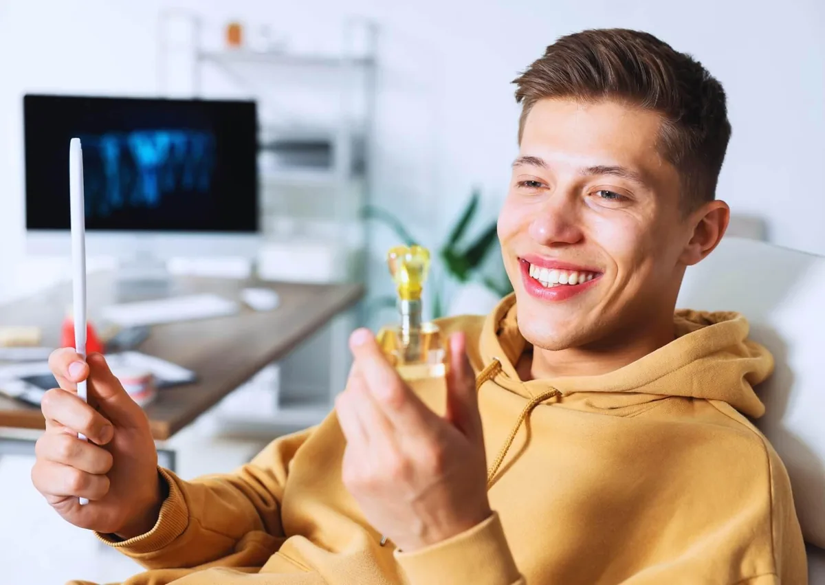Man considering dental implants while looking at a tooth model during a dental consultation.