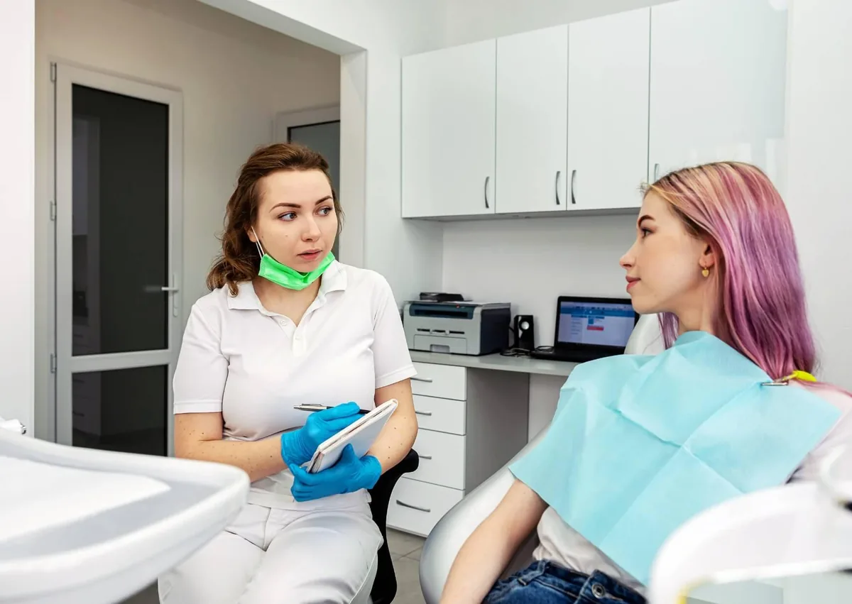 Dentist discussing aftercare and avoiding dairy after dental implant surgery with a patient.